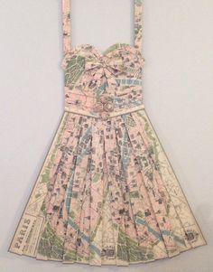 a dress made out of maps hanging on a wall