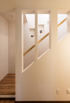 an empty room with wooden floors and white walls is seen from the doorway to the second floor