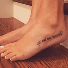 a woman's foot with the words you are my sunshine written on it