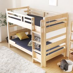 a wooden bunk bed sitting on top of a hard wood floor next to a white rug