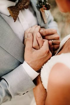 a bride and groom holding hands while standing next to each other