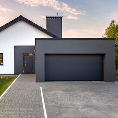 a house with a driveway in front of it and two garages on the other side