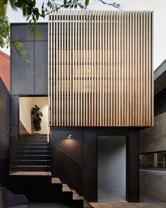 the stairs lead up to the upper level of this modern house with wood slats