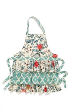 an apron made out of fabric with flowers and leaves on the front, hanging from a hook