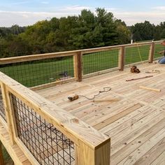 a man sitting on top of a wooden deck next to a fenced in area