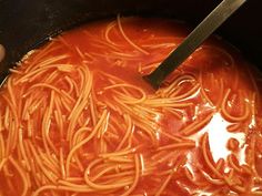 someone is stirring some noodles in a pot