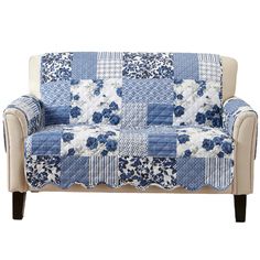 a blue and white patchwork loveseat with flowers on the back, sitting in front of a white background