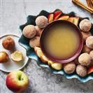 apples, cinnamons and other food items are arranged on a table with an orange juice in a bowl