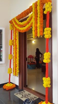 an entrance decorated with orange and yellow flowers for a wedding or special occasion to be attended