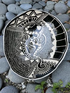 a black and white plate sitting on top of some rocks