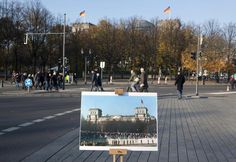 an easel with a painting on it sitting in the middle of a city street