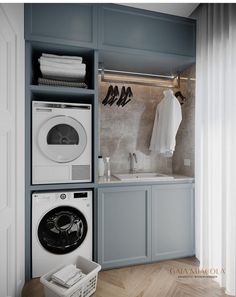 a washer and dryer in a laundry room with blue cabinets on the wall