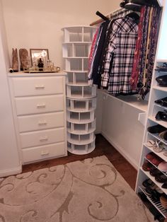 an organized closet with white shelves and shoes on the floor next to a large rug