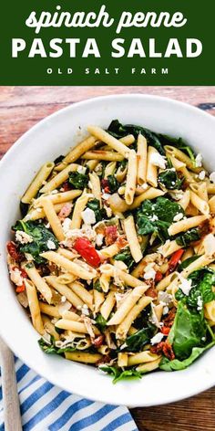 a white bowl filled with pasta and spinach