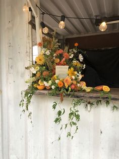 an arrangement of flowers and greenery on a window sill