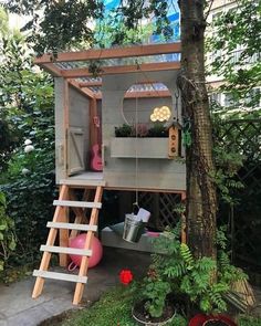 a tree house built into the side of a tree in a yard with stairs leading up to it