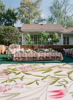 an outdoor dining area with tables and chairs set up for a formal function in front of a house