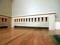 an empty room with wood flooring and white painted walls, along with a rug on the floor