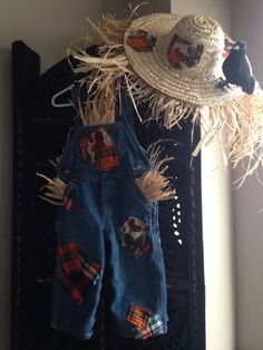 a scarecrow hat and overalls hanging on a wall