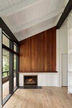 an empty room with wood paneling and a fireplace