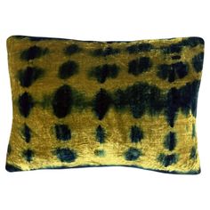 a yellow and black pillow with spots on it's side, against a white background