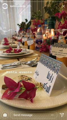 the table is set with flowers and place cards for guests to write their names on