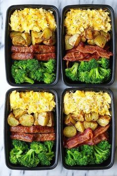 four black plastic containers filled with different types of food and broccoli on top of a marble counter