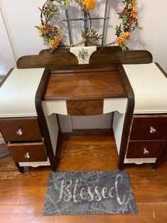 a wooden desk with two drawers and a sign on the floor next to it that says blessed