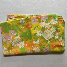 two yellow and green flowered cloths sitting on top of each other