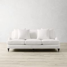 a white couch sitting on top of a hard wood floor