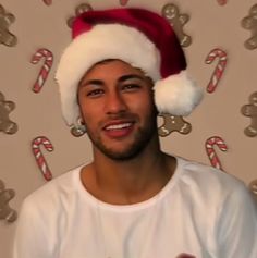 a man wearing a santa hat with candy canes on the wall in front of him