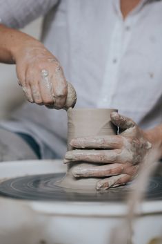 a person making a pot on a potter's wheel with their hands and fingers