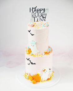 a three tiered cake decorated with halloween decorations and sprinkles on a white plate