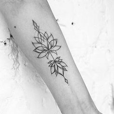 a black and white photo of a woman's arm with a flower tattoo on it