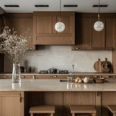 a kitchen with wooden cabinets and marble counter tops, along with two vases filled with flowers