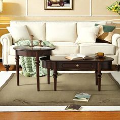 a living room scene with focus on the couch and coffee table, which is surrounded by books