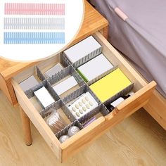 an open drawer in the middle of a bed next to a table with various items on it