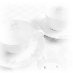 two white cups and saucers sitting on top of each other