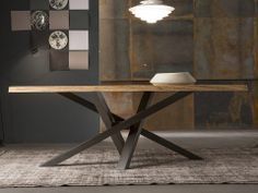 a wooden table sitting on top of a rug in front of a wall mounted light