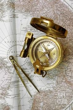 an old compass and some other tools on top of a map with the world in the background