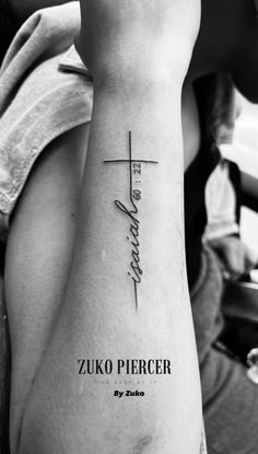 a woman's arm with a cross and the words zuko piercer on it