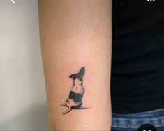 a small black and white dog tattoo on the left inner arm, with one paw in the air