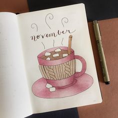 an open book with a drawing of a cup of hot chocolate and marshmallows