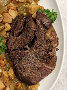 a white plate topped with meat and vegetables