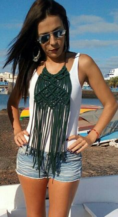 a woman standing on the edge of a boat with her hands on her hips and wearing sunglasses