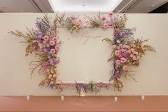 flowers and greenery are arranged on the wall