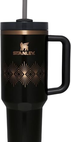 a black and gold travel mug with the word stanley printed on it's side