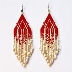 two pairs of red and white beaded earrings with pearls hanging from the ends of them