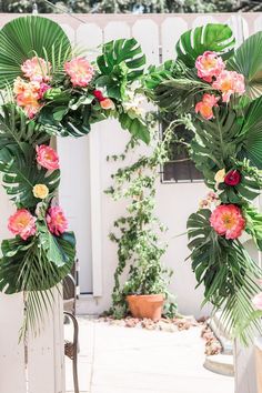 an arch made out of palm leaves and flowers