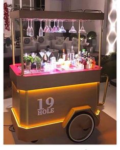 an old fashioned bar cart with wine glasses on the top and liquor bottles behind it